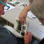 Zwei Männer gehen einen Stapel Grafiken durch.