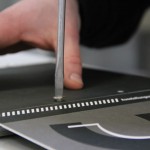 Mit einem Schraubenzieher werden zwei Schrauben in das fertige Buch eingesetzt.