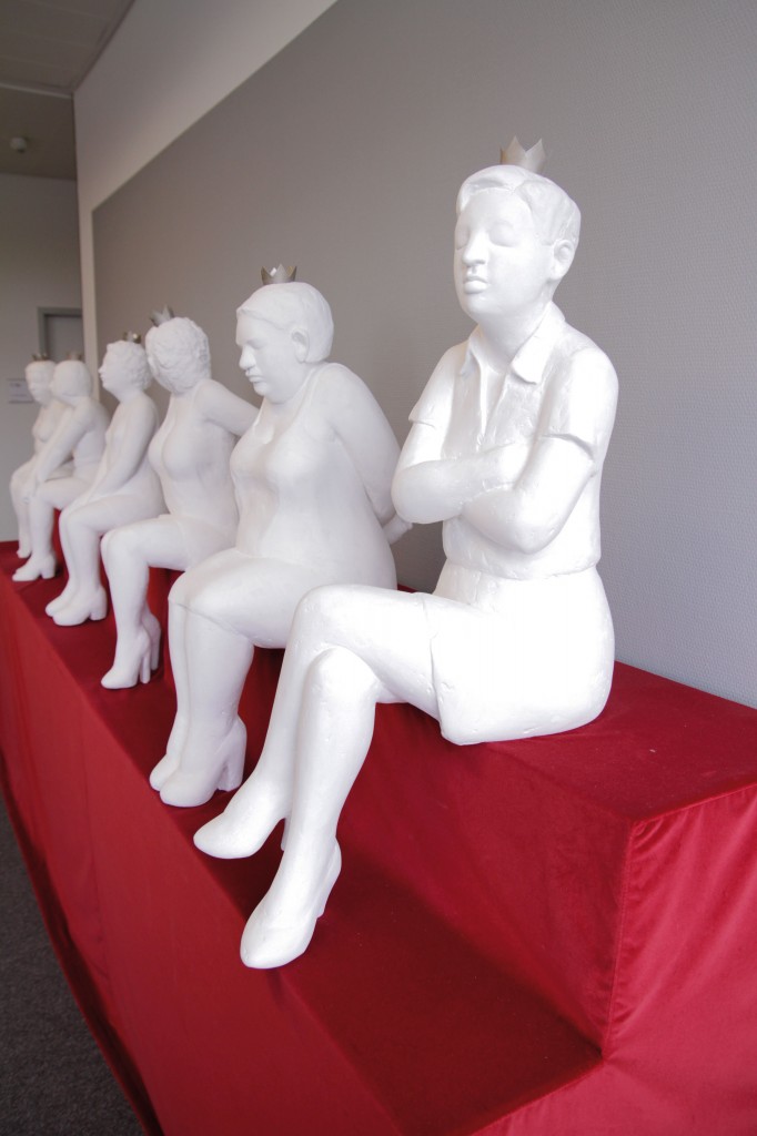 Sechs weiße Gipsfiguren, sind auf einem roten Tuch in Szene gesetzt.
