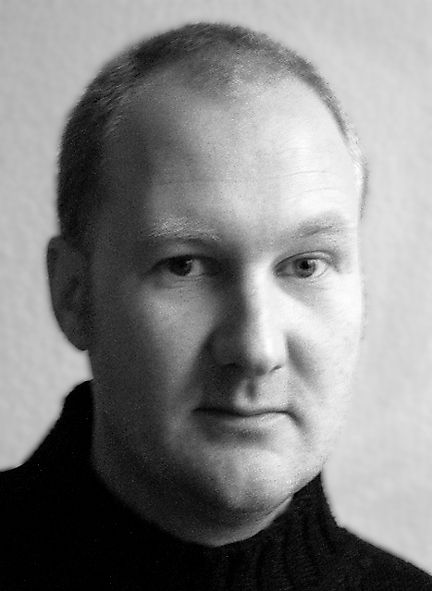 Eine schwarz-weiss Fotografie zeigt einen Mann in schwarzem Rollkragenpullover.