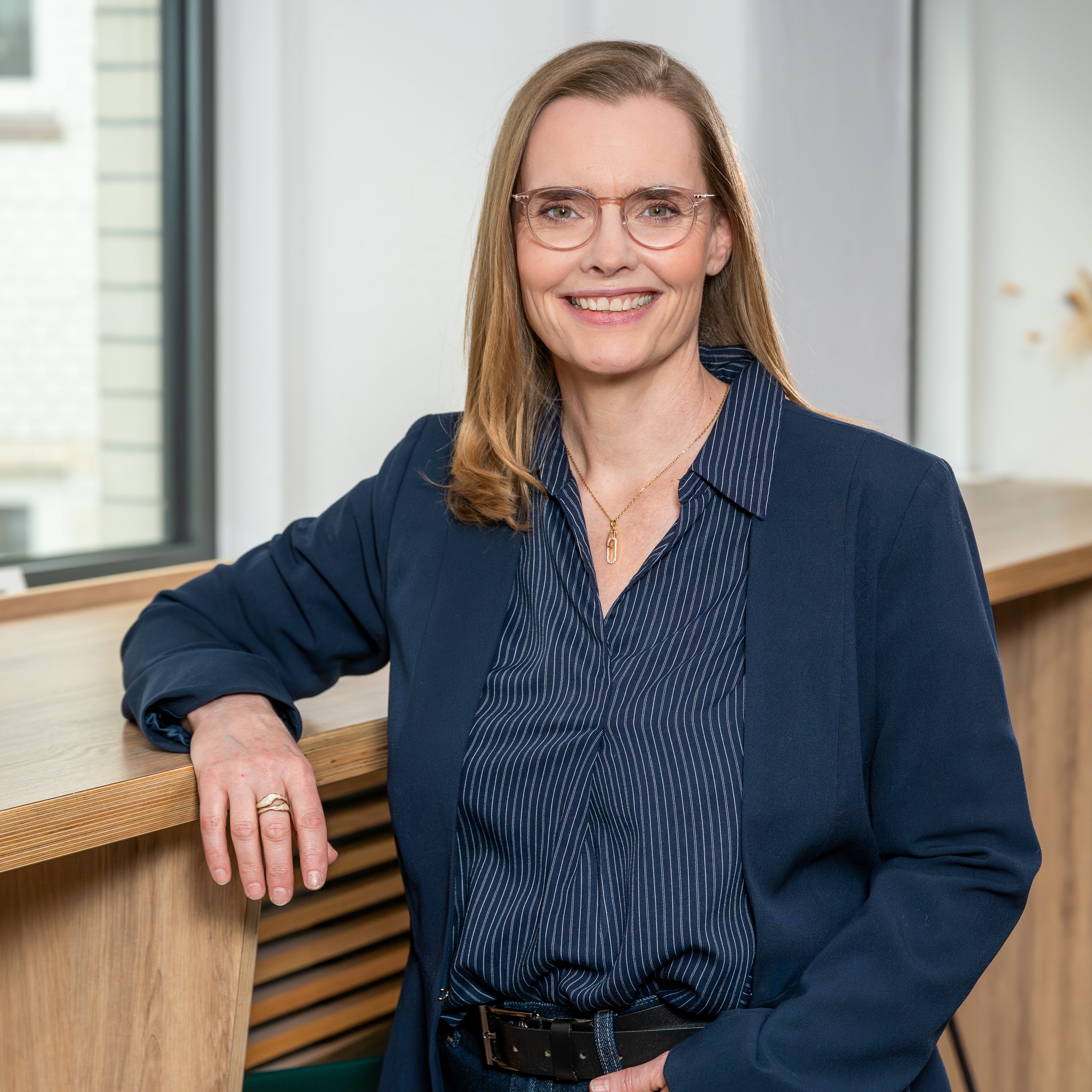 eine Frau lehnt sich an eine Fensterbank